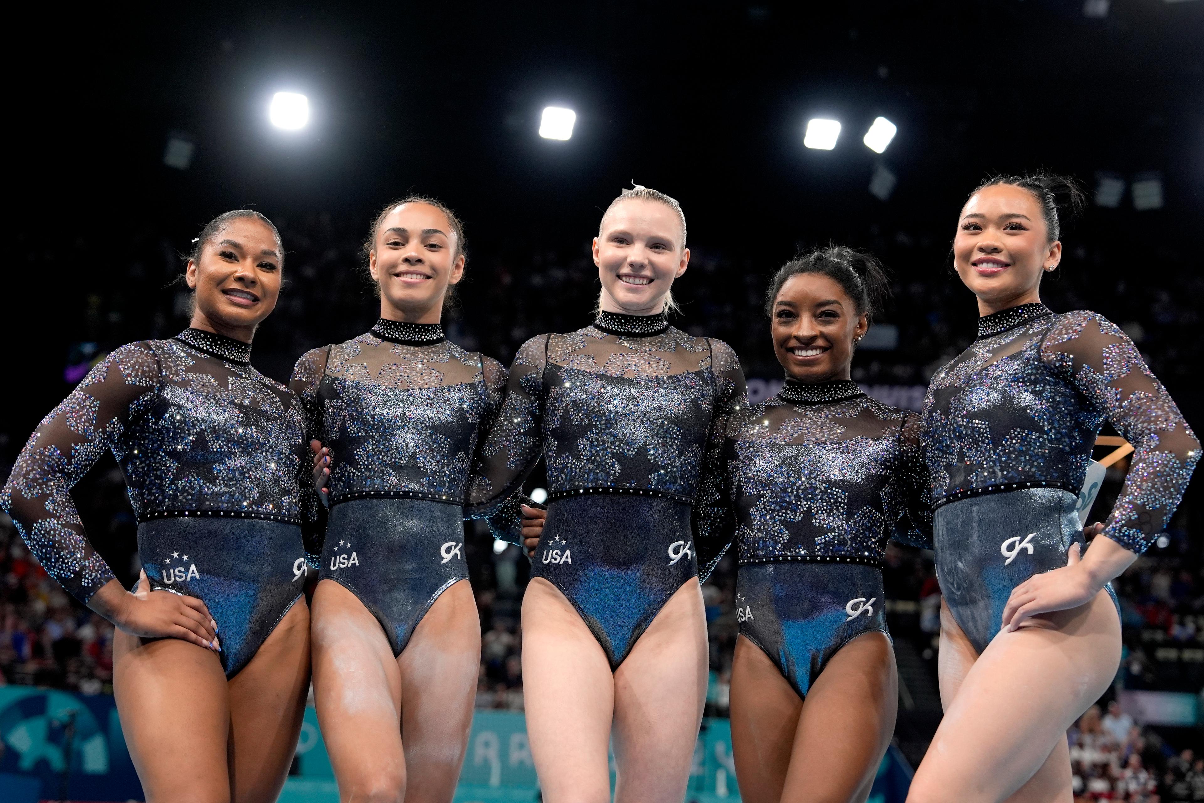 Five female gymnasts with team USA pose for a picture