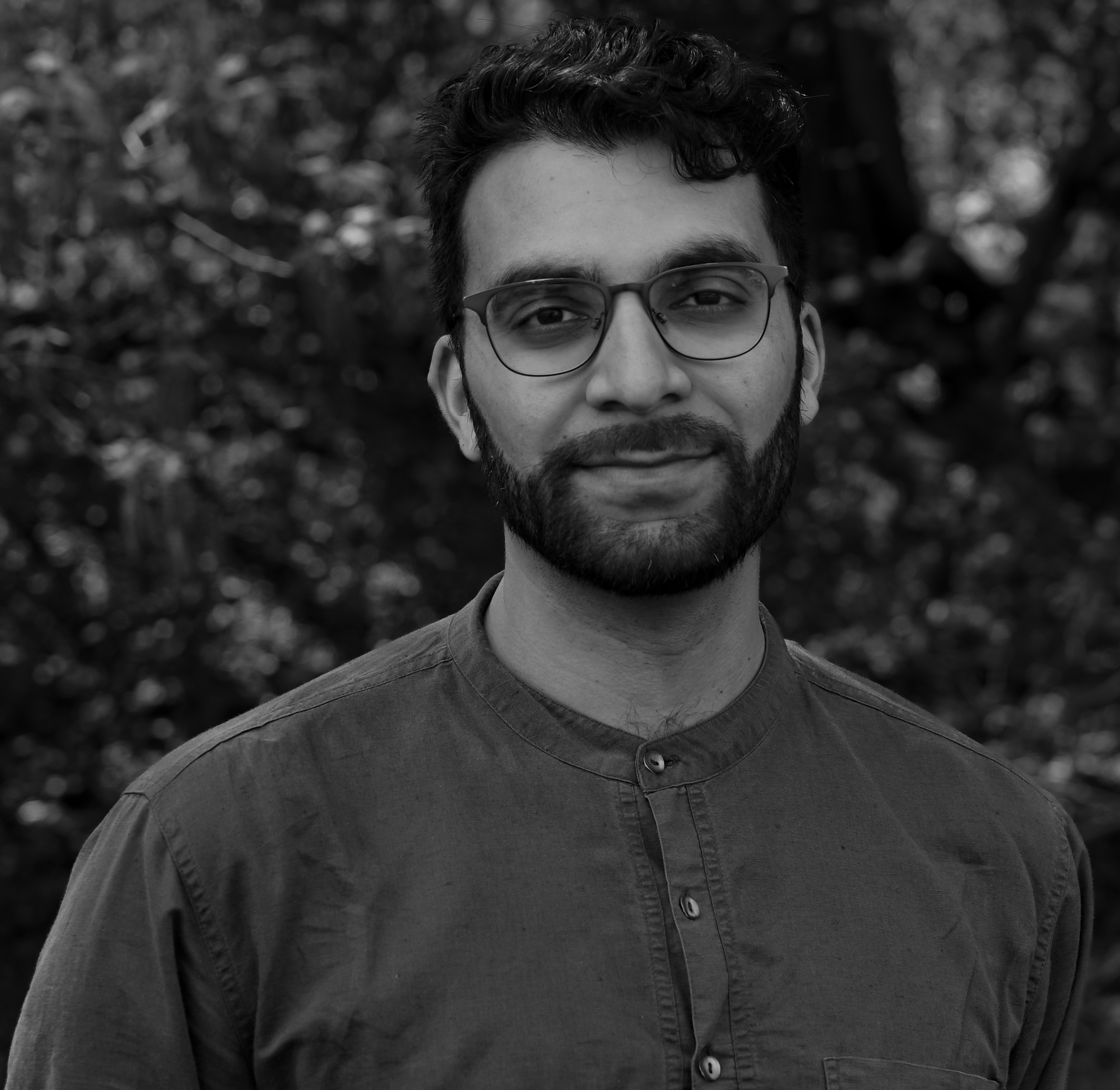 Man with dark hair, glasses and beard