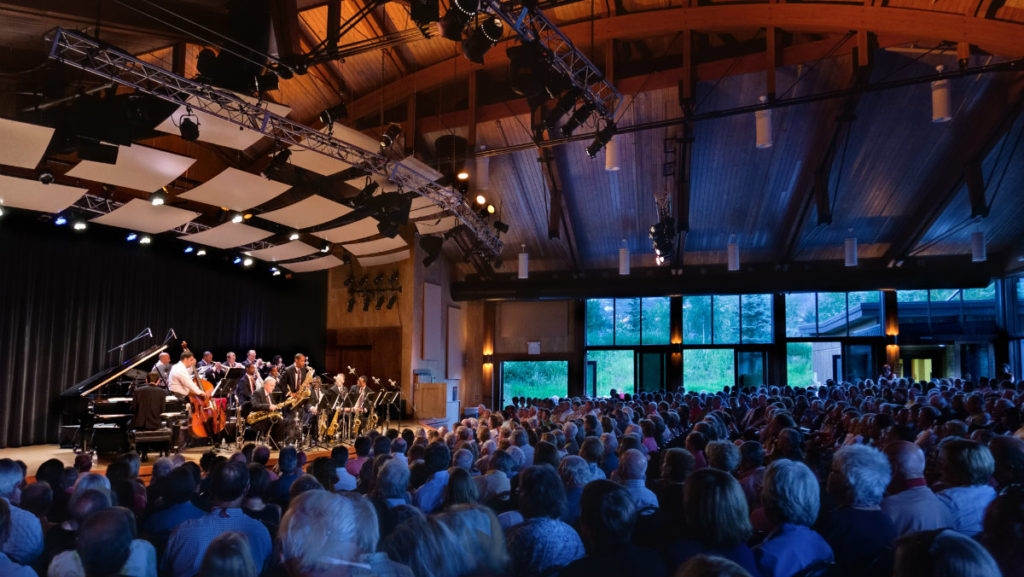 Trumpeter Wynton Marsalis performs with a jazz band for a full audience in a dimly lit room during the Strings Music Festival.